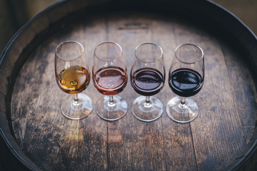 A curated flight of four wines arranged on a barrel top